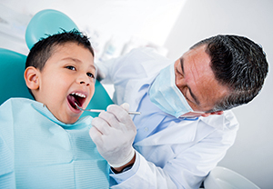 Niño siendo examinado por el dentista.